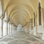 Historic stone arcade with arches and columns.